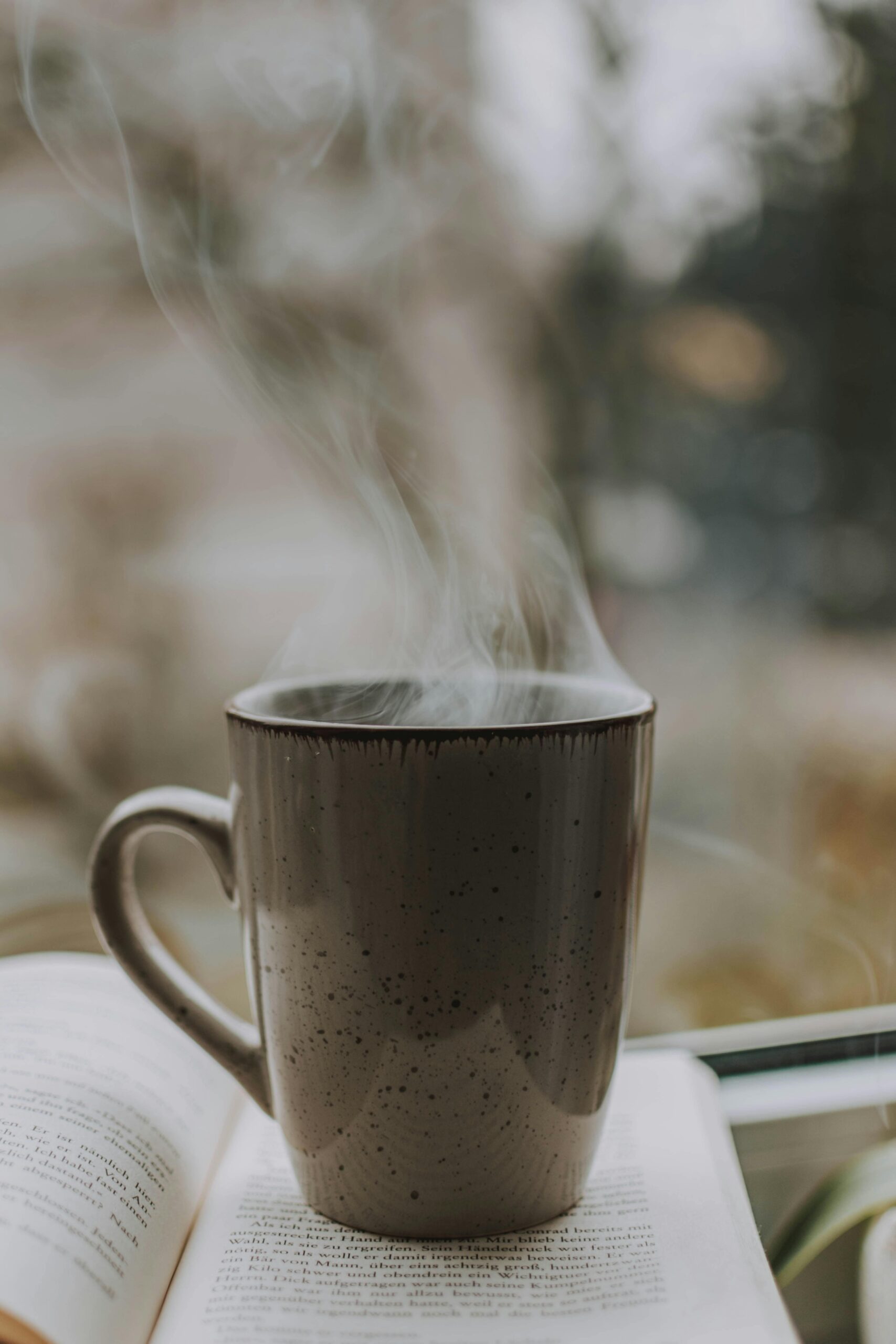 une tasse de café fumante avec un livre